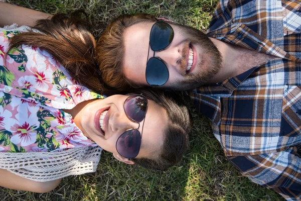 Paar lächelnd im Gras liegend — Stockfoto