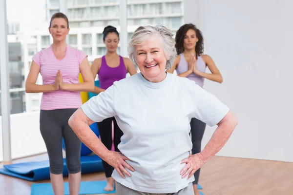 Äldre kvinna med händerna på hip stående i gym — Stockfoto