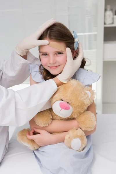 Doctor making plaster in little girl — Stock Photo, Image