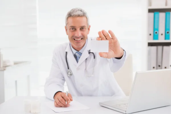 Médico sonriente mostrando un blanco — Foto de Stock