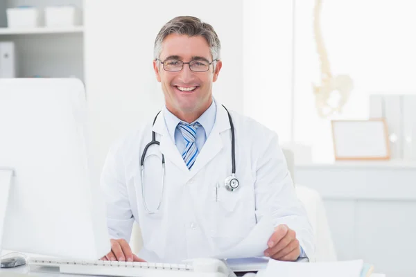 Médico masculino revisando documentos en la mesa — Foto de Stock