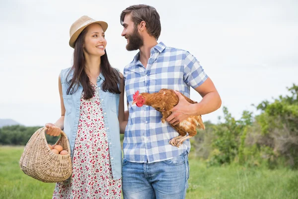 Agricultores felizes segurando frango e ovos — Fotografia de Stock