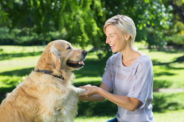 Blondine spielt mit Hund im Park — Stockfoto