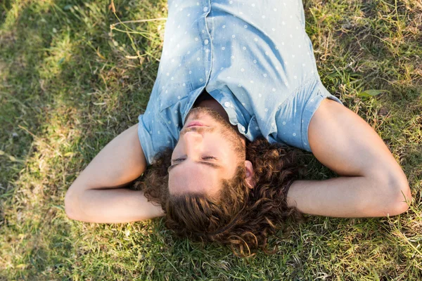 Jonge man liggen in het park — Stockfoto