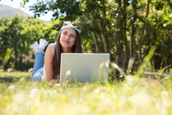 Ładna brunetka korzysta z laptopa w parku — Zdjęcie stockowe