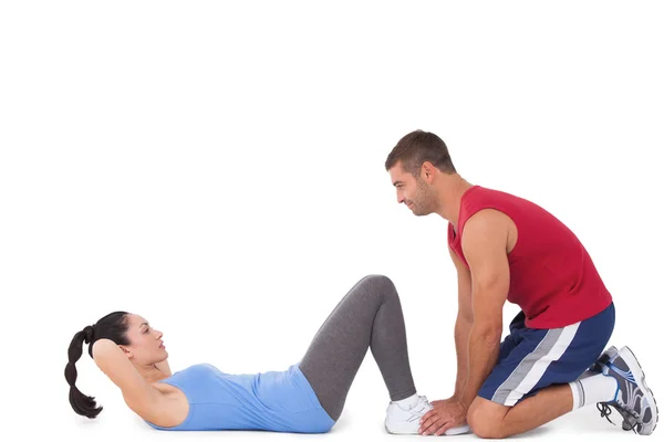 Trenér s ženou dělá sit ups — Stock fotografie