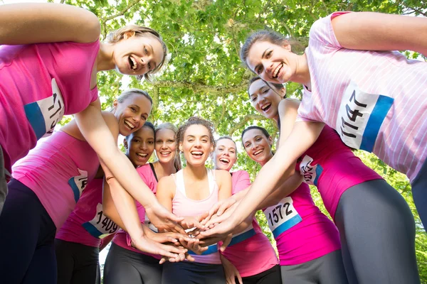Smiling women running for breast cancer awareness — Stock Photo, Image
