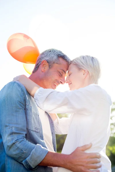 Coppia carina che tiene palloncini al parco — Foto Stock