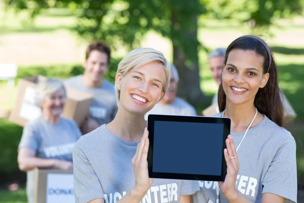 Volunteer friends showing tablet pc screen — Stock Photo, Image