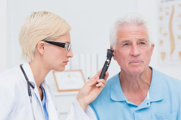 Médico examinando pacientes do sexo masculino orelha — Fotografia de Stock