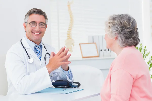 Médico con paciente femenino en la mesa —  Fotos de Stock