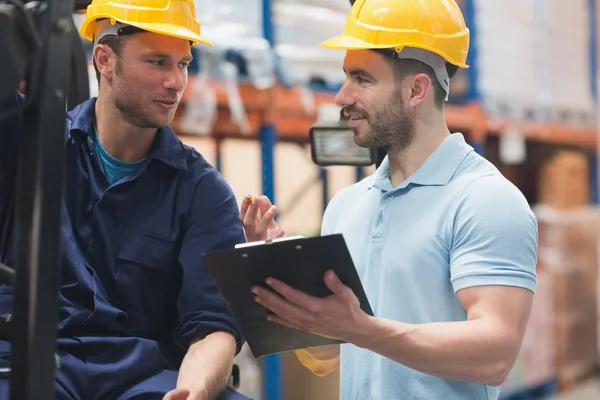 Smiling warehouse workers talking together — Stock Photo, Image