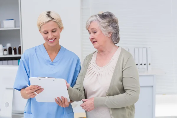 Verpleegkundige en patiënt bespreken over Klembord — Stockfoto