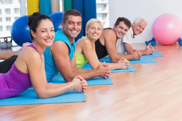 Pessoas relaxando em tapetes de exercício no estúdio de fitness — Fotografia de Stock