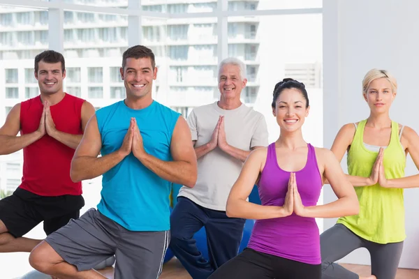 Les gens qui pratiquent la pose d'arbre dans un studio de fitness — Photo