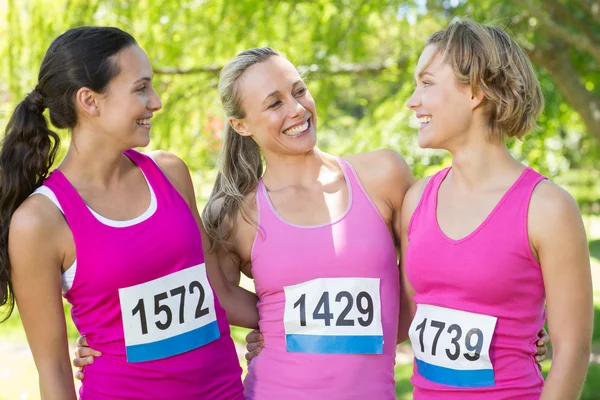 Smiling women running for breast cancer awareness — Stock Photo, Image