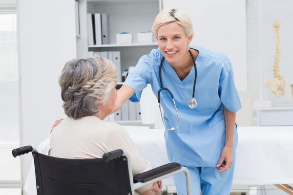 Enfermeira consoladora paciente sentado em cadeira de rodas — Fotografia de Stock