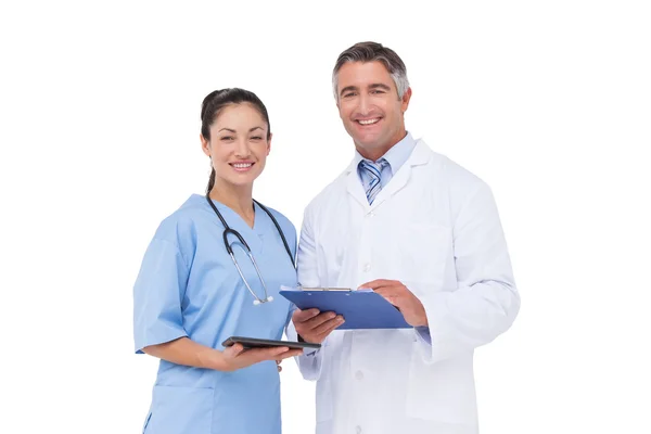 Доктор и медсестра улыбаются в камеру — стоковое фото