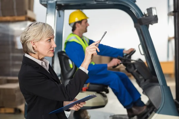 Warehouse manager checking her inventory — Stock Photo, Image