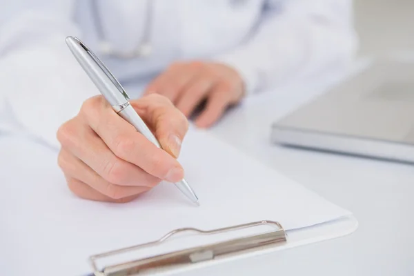 Doctor writing on clipboard — Stock Photo, Image