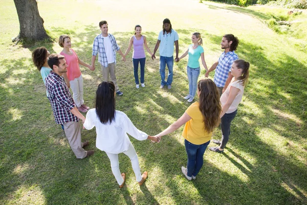 Glückliche Freunde im Park halten Händchen — Stockfoto