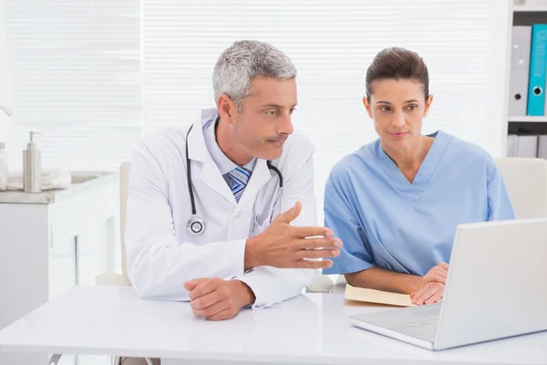 Los médicos mirando a la computadora portátil — Foto de Stock