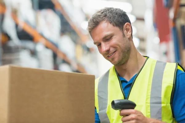 Smiling manual worker scanning package — Stock Photo, Image