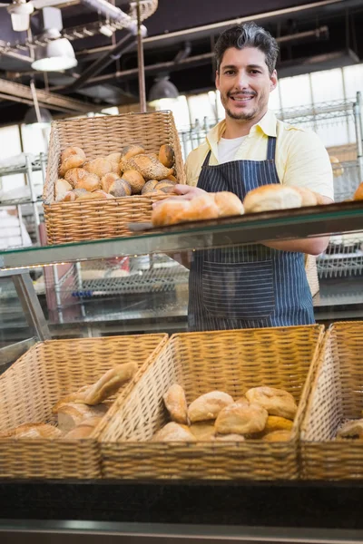 Trabalhador sorridente mostrando cesta de pão — Fotografia de Stock