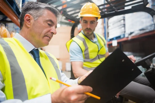 Forklift driver talking with his manager — Stock Photo, Image