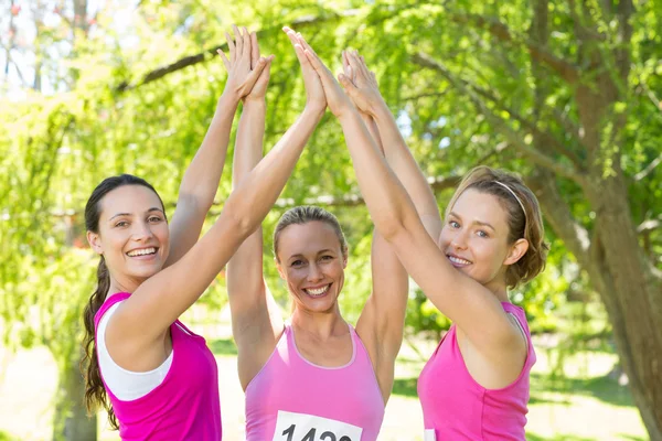 Mujeres sonrientes corriendo por la conciencia del cáncer de mama — Foto de Stock