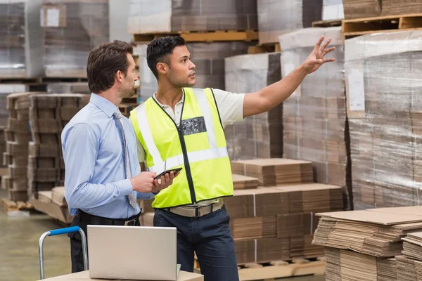 Warehouse worker showing something to manager — Stock Photo, Image