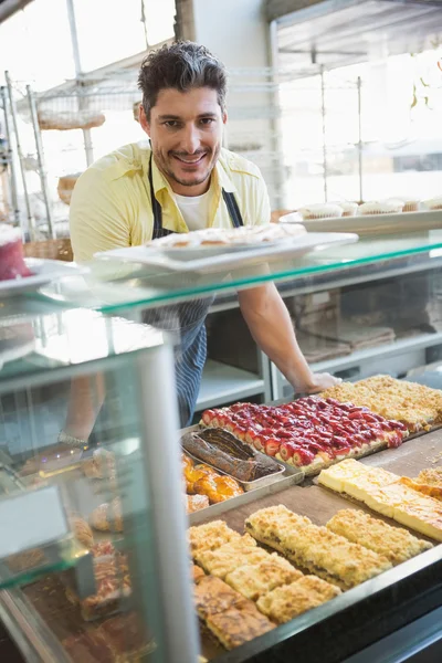 Operaio sorridente posa dietro il bancone — Foto Stock