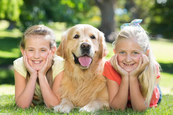 Zusters glimlachen op camera met hond — Stockfoto