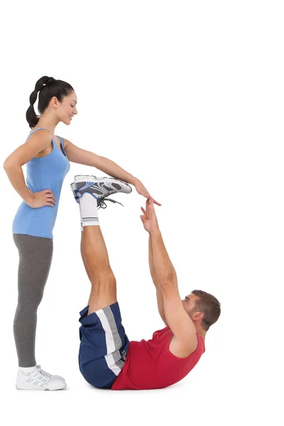 Trainer hilft ihrem Klienten Beine zu dehnen — Stockfoto