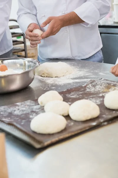 Колеги кладуть тісто на піднос для випічки — стокове фото