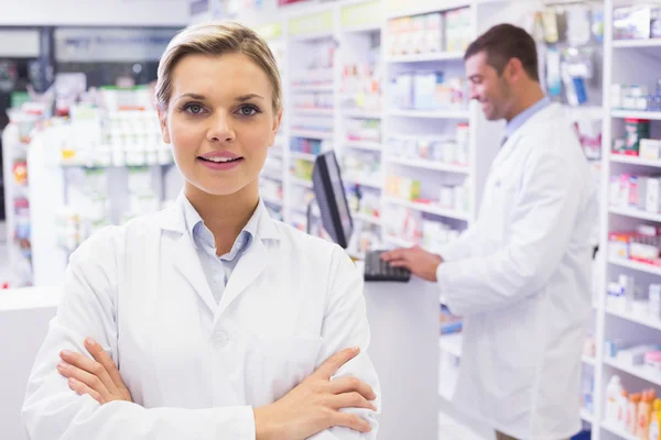 Smiling pharmacist standing with arms crossed — Stock Photo, Image