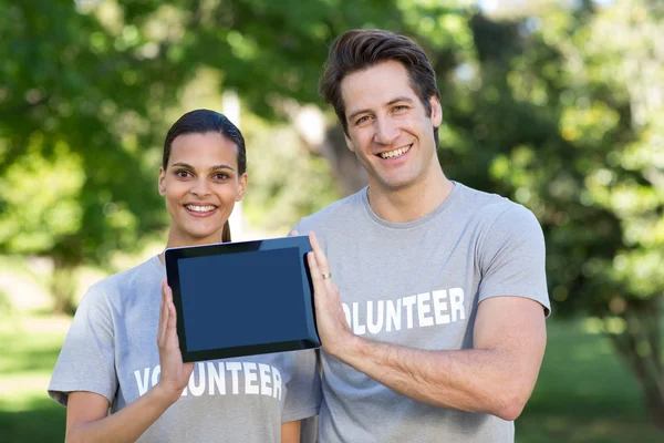 Pareja voluntaria sosteniendo la tableta pc — Foto de Stock