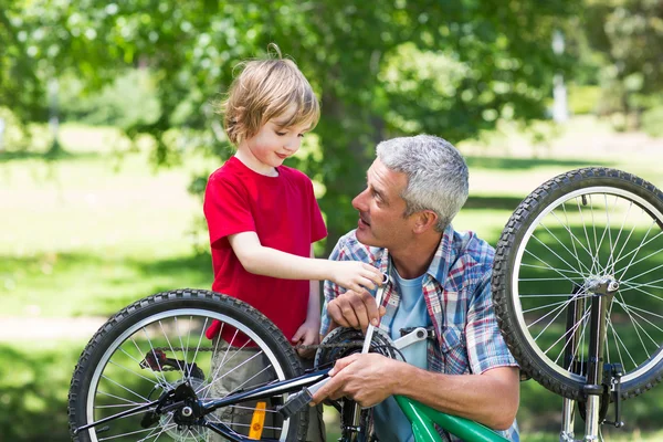 Padre e suo figlio che riparano una bici — Foto Stock