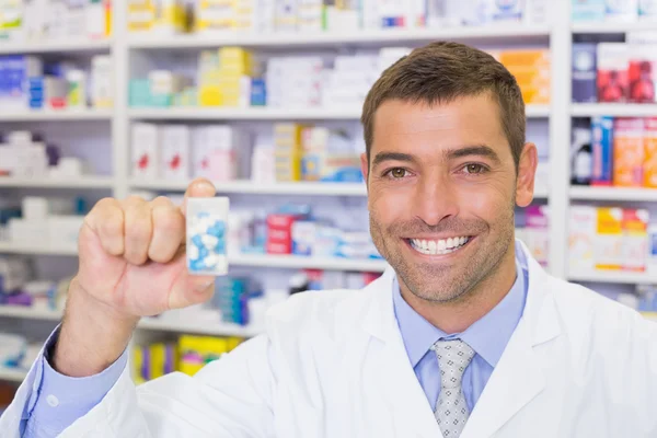 Farmacêutico bonito mostrando frasco remédio — Fotografia de Stock