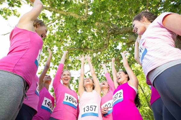 Smiling women running for breast cancer awareness — Stock Photo, Image