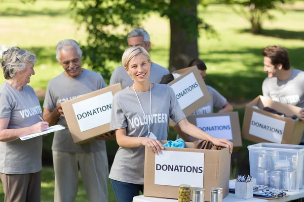 Happy family holding donations boxes — Stock Photo, Image