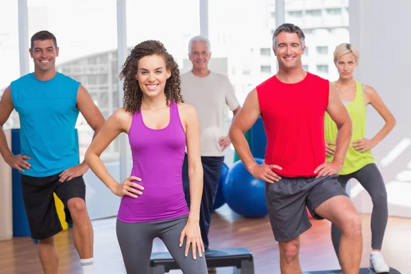 Instructor con clase de fitness realizando ejercicios aeróbicos paso a paso —  Fotos de Stock