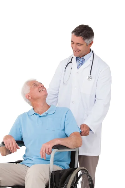 Врач толкает пожилого пациента в инвалидном кресле — стоковое фото
