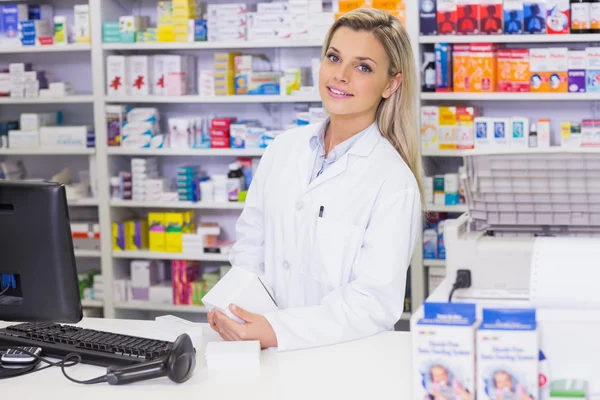 Pharmacist holding medicines looking at camera — Stock Photo, Image