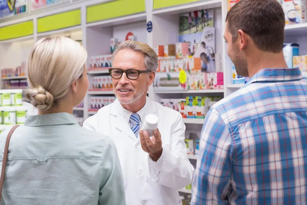 Farmacêutico explicando pílulas para o paciente — Fotografia de Stock