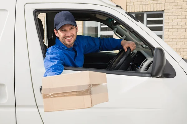 Delivery driver offering parcel from his van — Stock Photo, Image