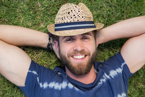 Handsome hipster lying on grass — Stock Photo, Image