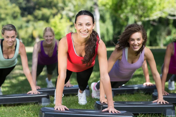 Fitness grupp med steg i park — Stockfoto