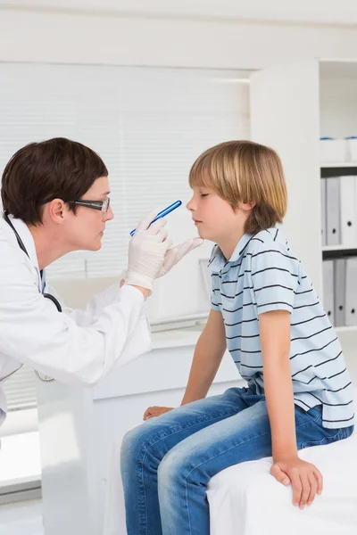 Docteur examine garçon avec la lumière — Photo