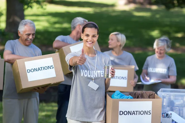 Volunteer brunette smiling with thumb up — Stock Photo, Image